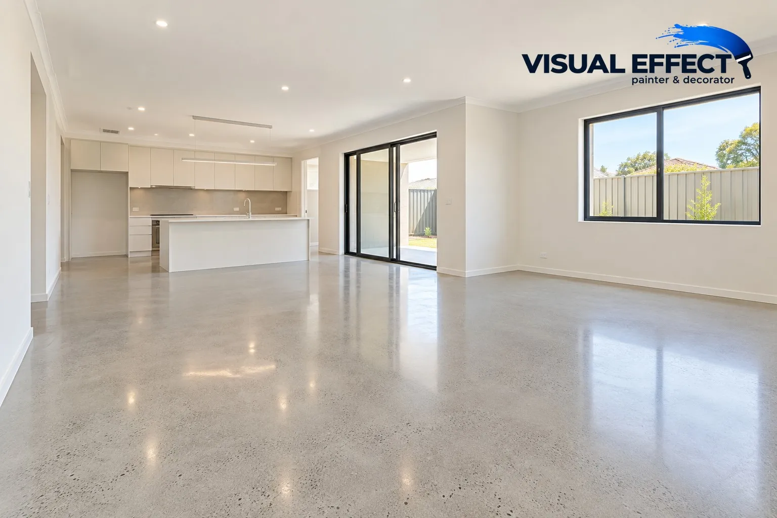 Empty open-plan living area of a new home with warm white walls